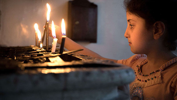 Mädchen zündet Kerzen an in der syrisch-orthodoxen Gemeinde in Qamischli in Syrien